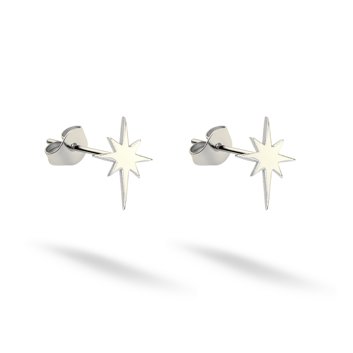 Cool-toned 14K white gold compass star studs arranged beside their backings