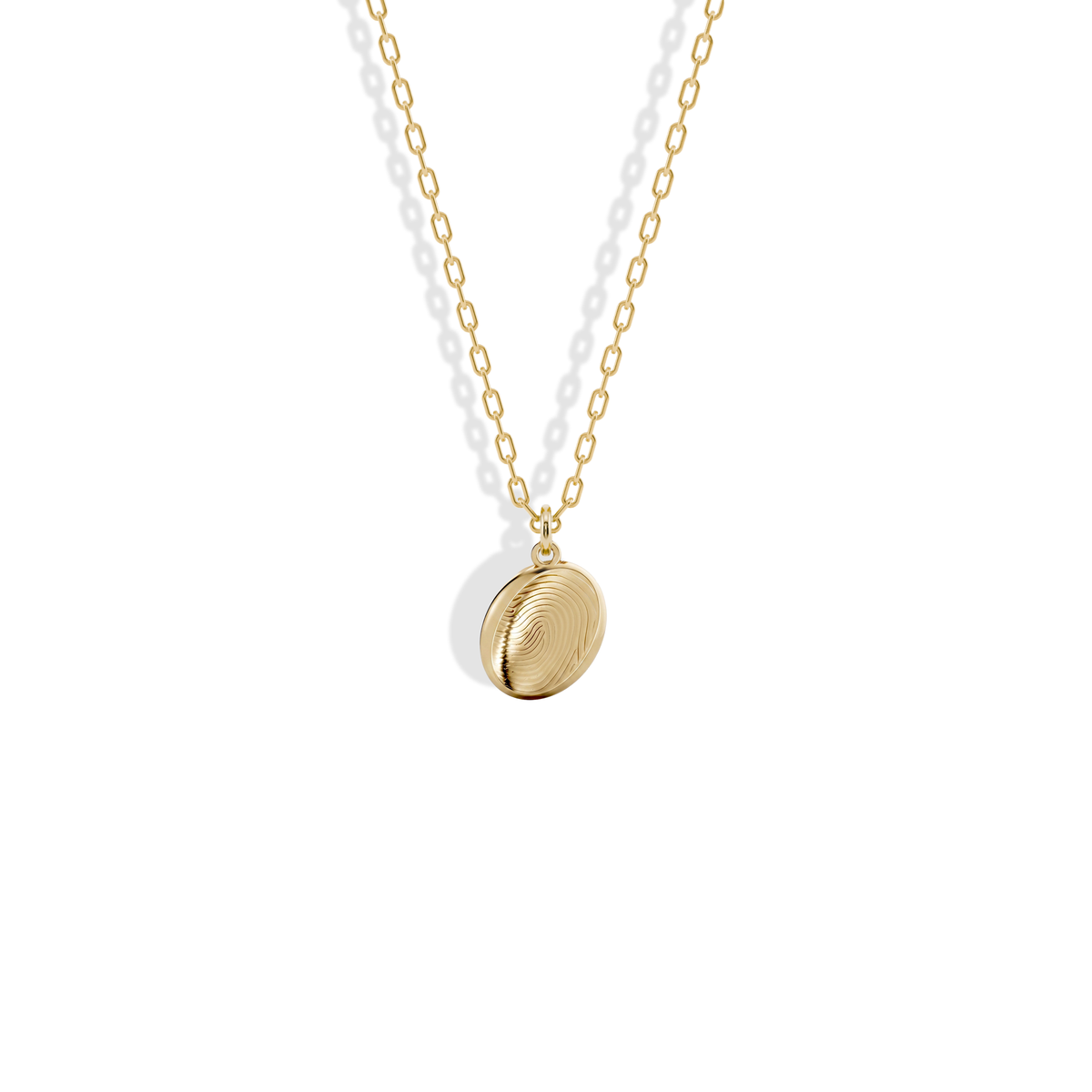 Close studio view of the Fingerprint Oval Custom Necklace 14K Gold / Silver, fingerprint ridges engraved into yellow gold