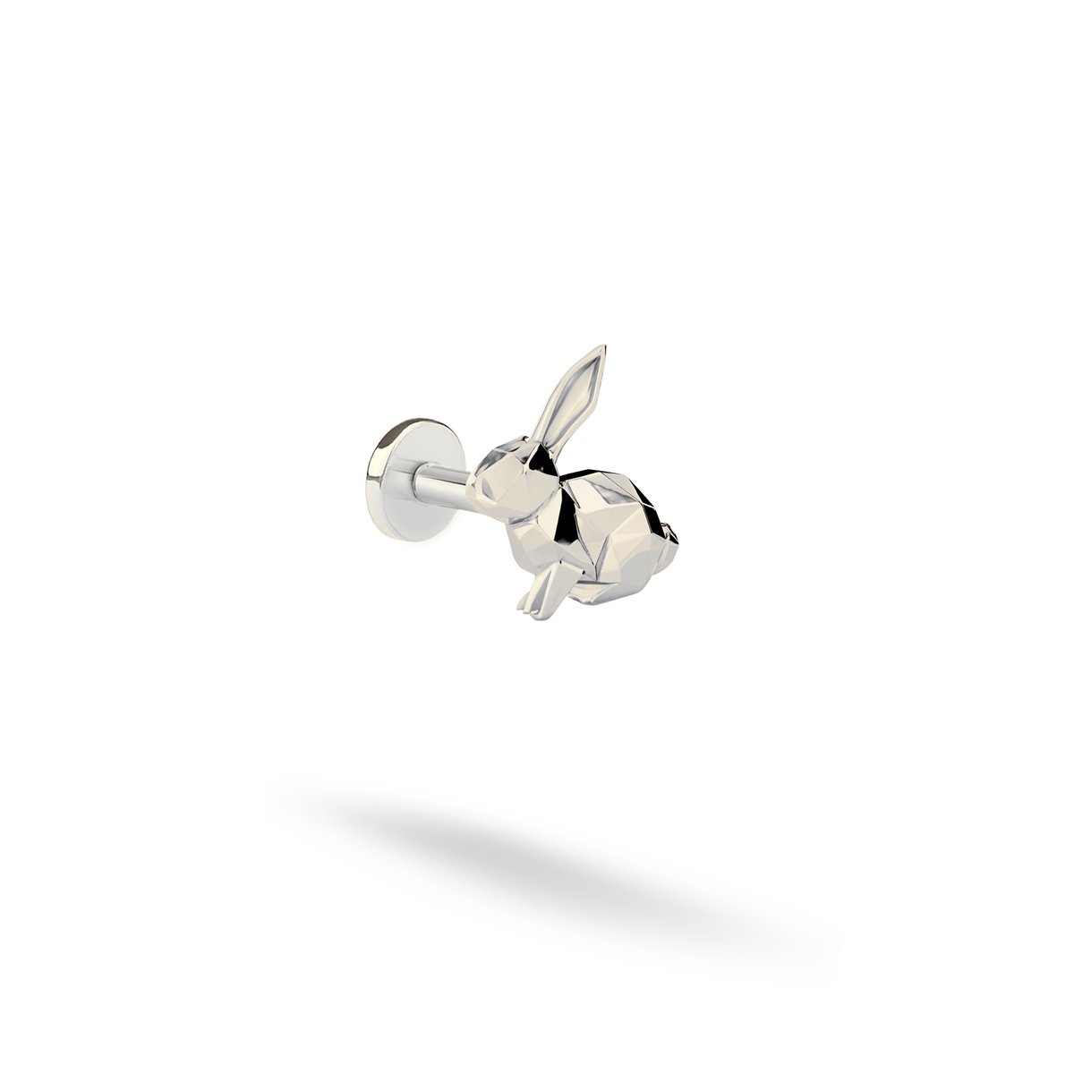 White gold sharpens the low-poly planes of the rabbit flatback piercing on an opaque studio background.