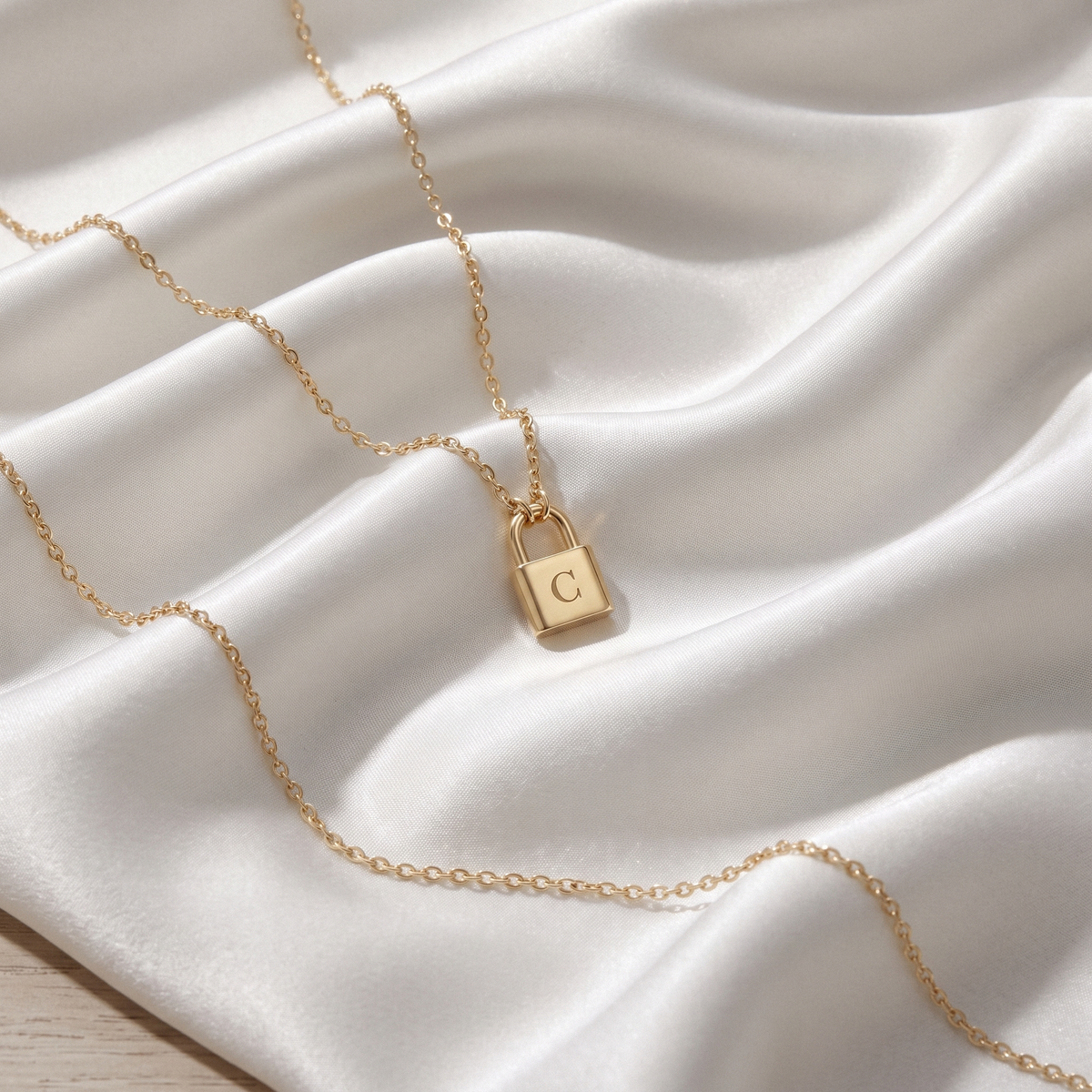 Lock Initial Custom Necklace in 14K Solid Gold and Sterling Silver displayed on soft fabric
