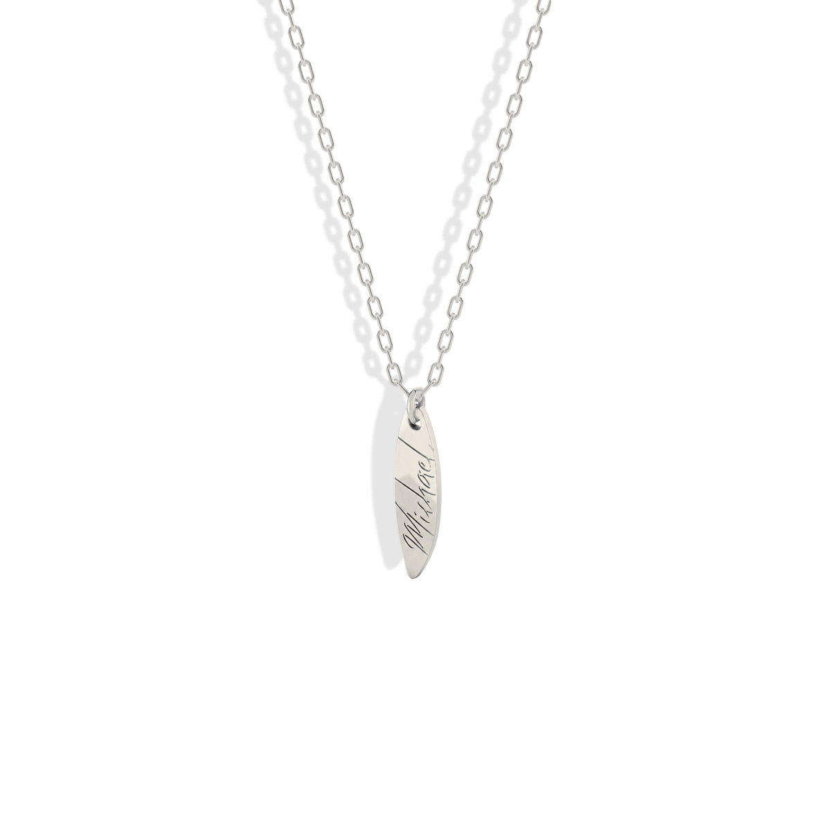Pale 14K white gold keeps the engraved name crisp on this surfboard necklace
