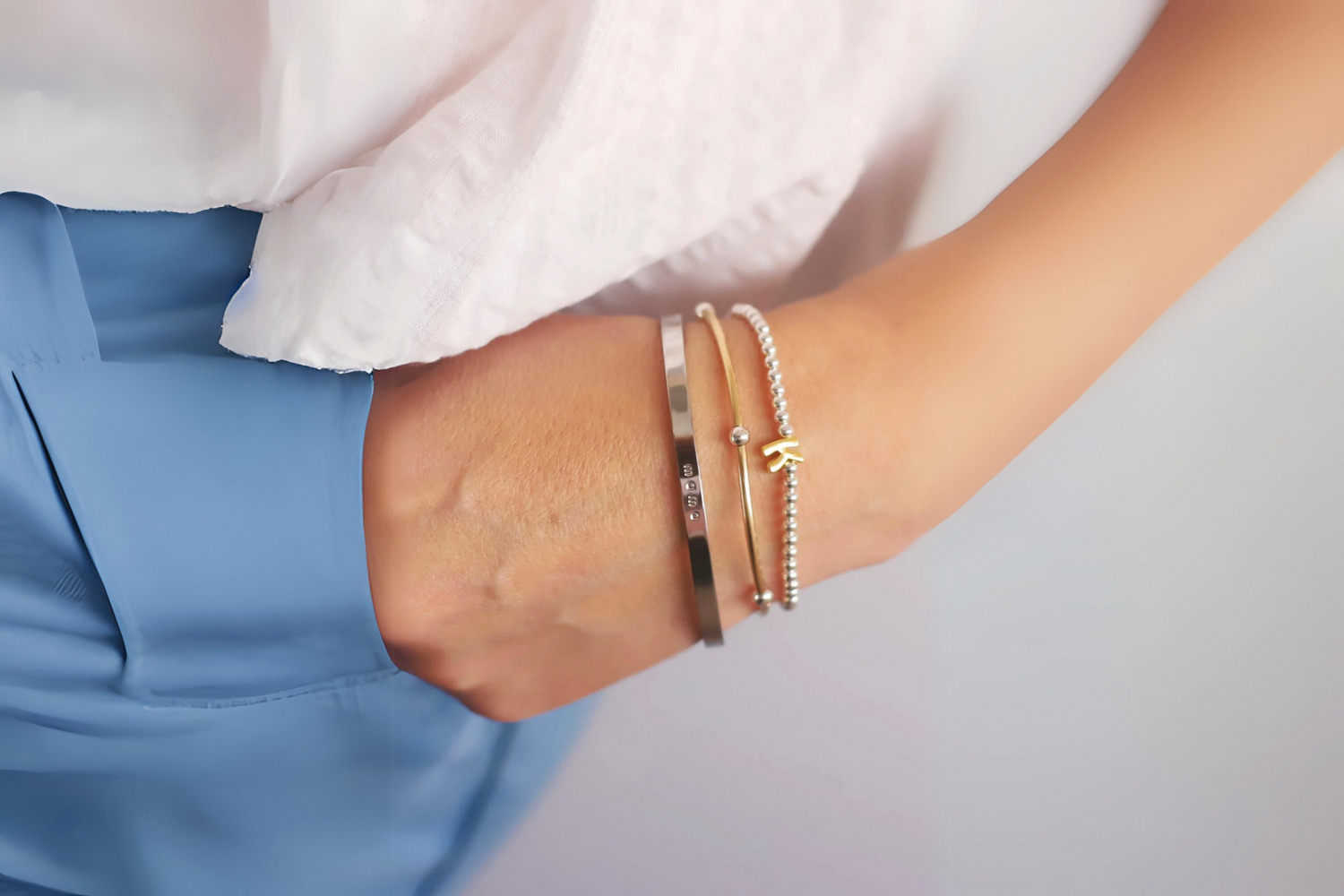 Side-by-side gold and silver jewelry pieces displayed on warm and cool-toned skin, showing how different metals complement undertones.