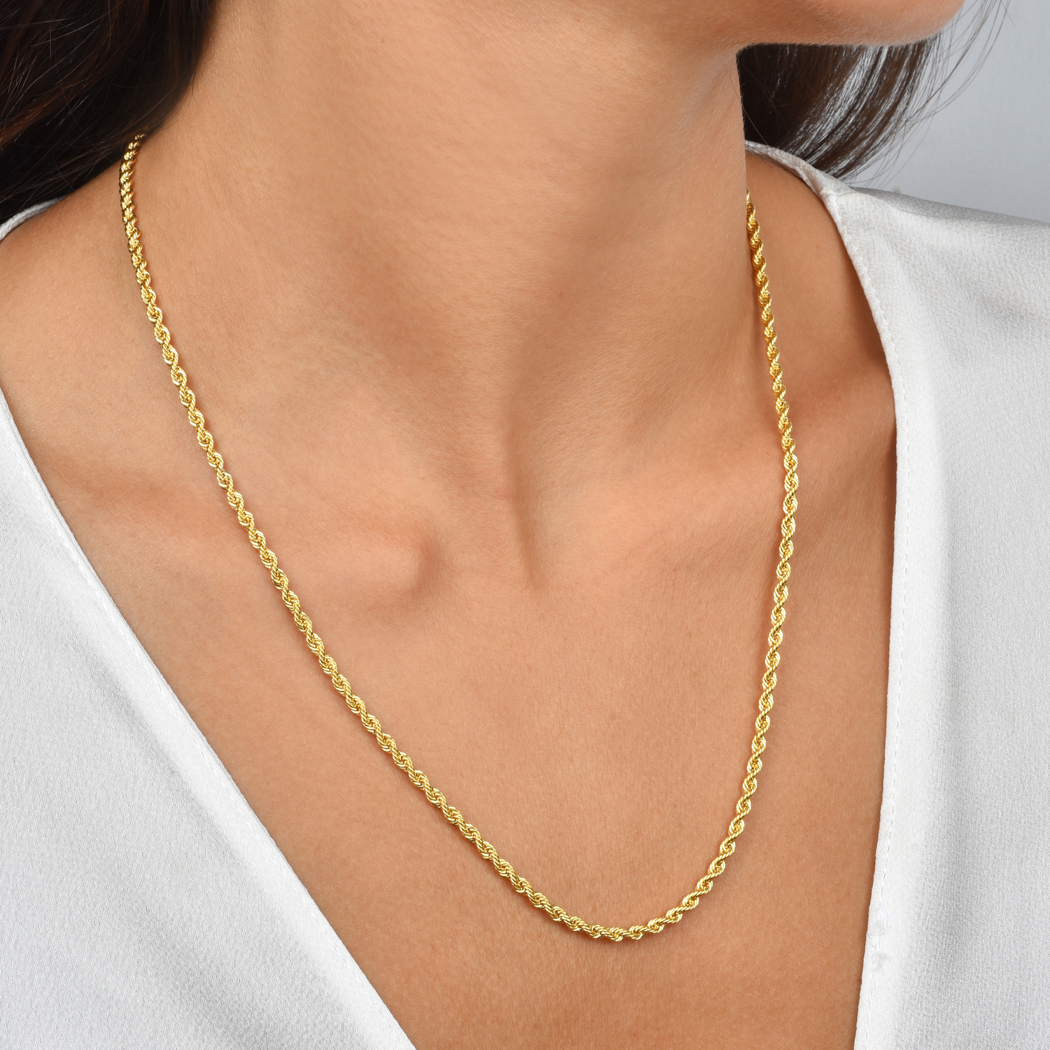 A curated collection of 14K gold chain necklaces featuring cable, curb, and box chains laid out on a neutral background.