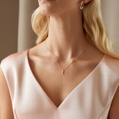 Seahorse necklace worn with a pale pink wrap top, pendant sitting high on the chest