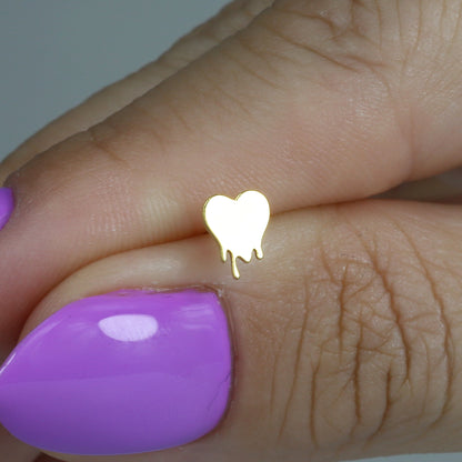 Hand holding the fluid heart studs to show their small scale and organic outline