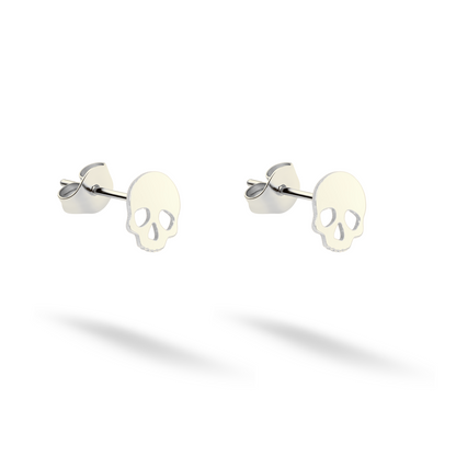 Compact skull studs shown in clean 14K white gold with matching backs
