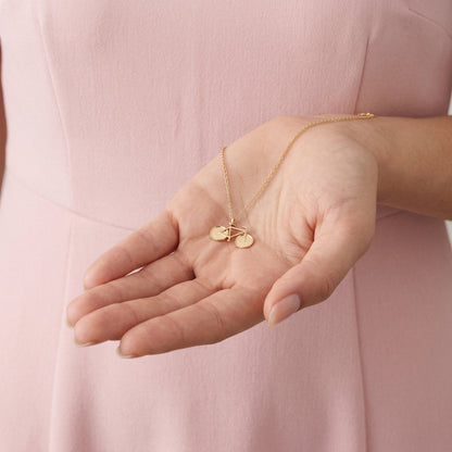 Small gold bicycle pendant resting in an open palm