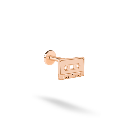 Warm rose gold softens the cassette tape motif while keeping its nostalgic controls clearly defined.
