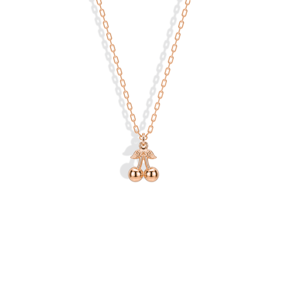 Rose gold cherry pendant, with warm pink metal highlighting the rounded fruit and textured stem