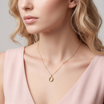 Fingerprint oval necklace worn with a pink off-shoulder top
