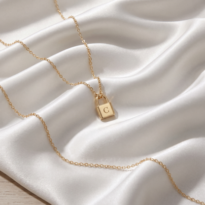 Lock Initial Custom Necklace in 14K Solid Gold and Sterling Silver displayed on soft fabric