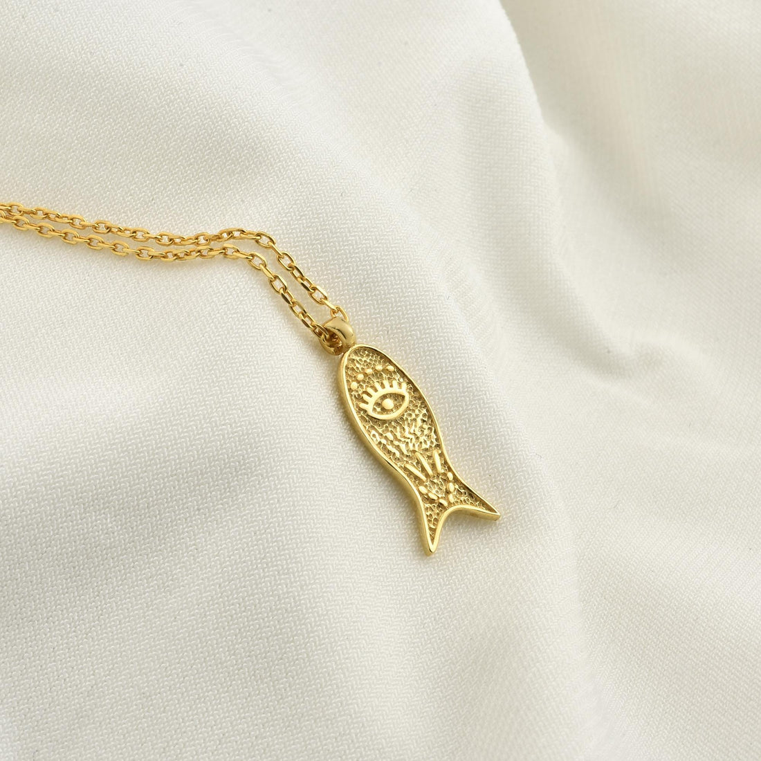 Hand crafted 14k gold necklace with the iconic Lucky Fish Design displayed on a neutral background.