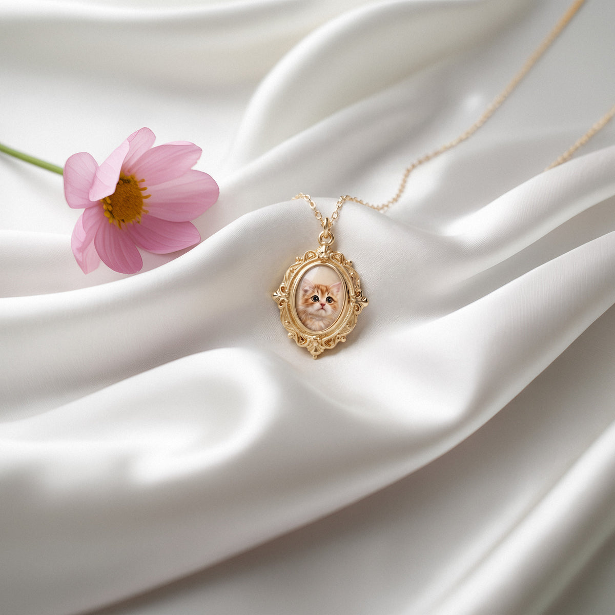 Enamel photo locket placed on folds of white satin, its chain trailing towards a pink bloom