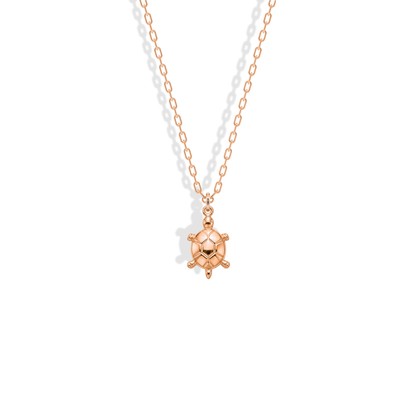 Rose gold sea turtle, its shell plates deepened by the blush metal