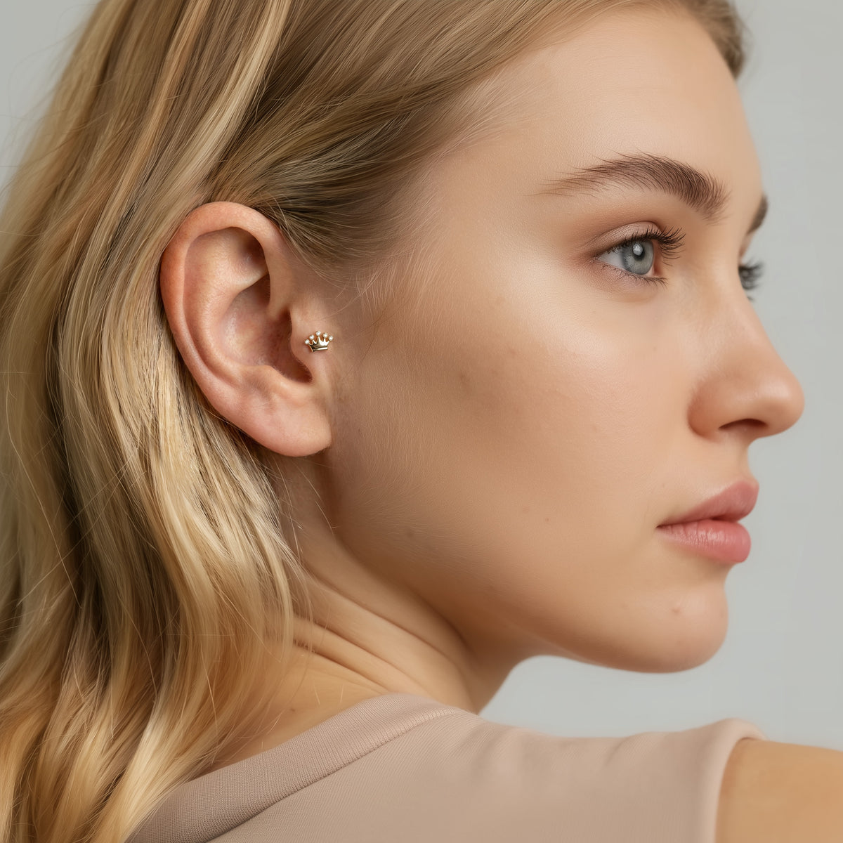 Model wears the stone crown flatback as a refined royal accent in a balanced everyday ear stack.