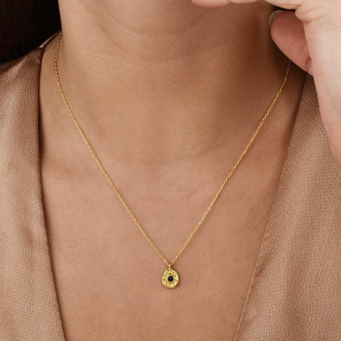 Model wearing the Sun Green Stone necklace, highlighting its golden glow and vivid centerpiece.