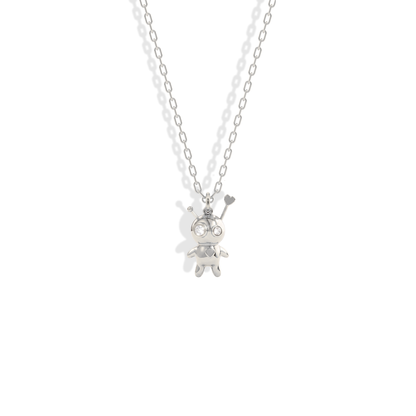 Sharp stitched outline of the doll pendant picked out in cool 14K white gold